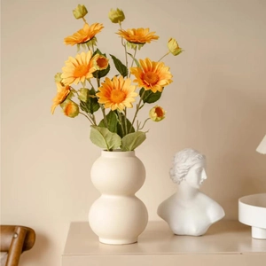 Modern minimalist off-white ceramic gourd vase with yellow sunflowers for home decor
