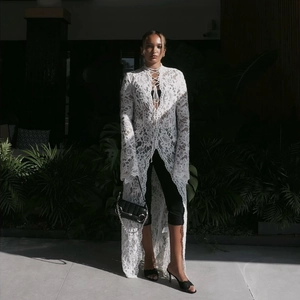 Vista dettagliata del cardigan in pizzo bianco elegante con abito nero chic