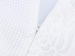 Macro detail of high-quality invisible zipper on white mesh and lace floral dress