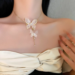 Detail of butterfly necklace with pearls, crystals, and fringe on model's neckline