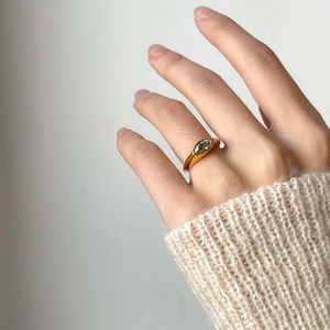 Detailed view of marquise-cut zircon set in a golden band on a model's hand