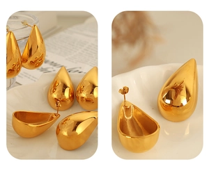 Macro view of water-drop earrings in polished 18k gold plating on a ceramic tray