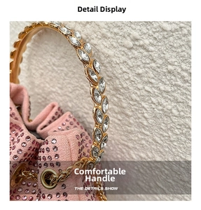 Close-up of pink rhinestone bucket bag with crystal-encrusted gold metal handle detail