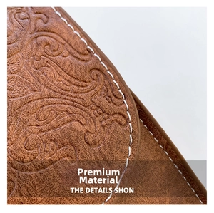 Detail view of brown leather handbag featuring retro floral embossing and white stitching