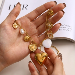 Vue détaillée du bracelet doré multicharmes avec pendentifs cœur cadenas et perle baroque