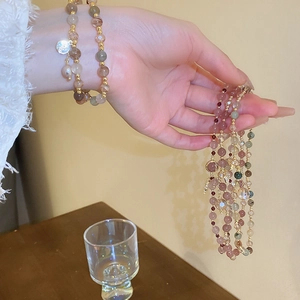 Close-up of multilayer freshwater pearl bracelet with colorful crystal beads and gold pendant