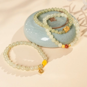 Close-up of retro jade beads with golden 'Fu' pendant and decorative accents