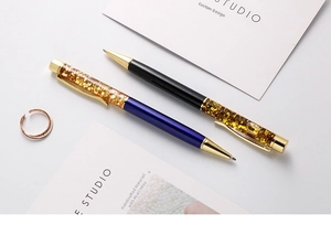Detail of metal glitter pens with floating gold foil and glossy finish in purple and black