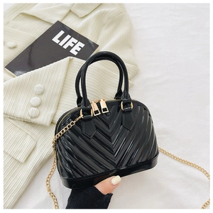 Detail of black jelly shell bag featuring V-shaped embossing and a golden chain strap