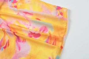Gros plan sur un tissu mousseline imprimé floral avec texture plissée jaune et rose