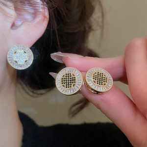 Detailed view of vintage gold plated round stud earrings with black and white zircon stones