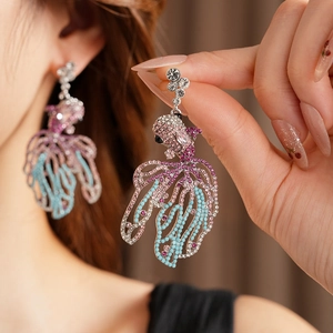 Gros plan sur les boucles d'oreilles poisson avec strass roses et bleus vintage