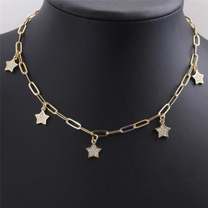 Gros plan d'un collier chaîne trombone doré avec pendentifs étoiles sur buste noir