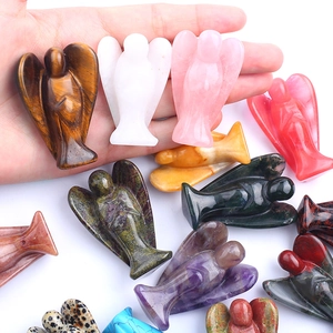 Natural crystal angel figurines carved from tiger eye, quartz and amethyst in hand