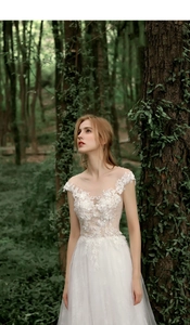 Detailed view of floral lace embroidery and sheer mesh on a woodland bridal gown