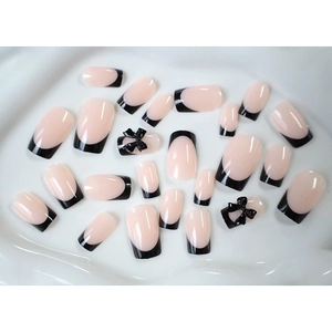 Sweet French press-on nails with black tips and 3D bow accents on pink base