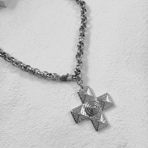 Detailed close-up of 18k gold plated cross pendant with pyramid texture on link chain