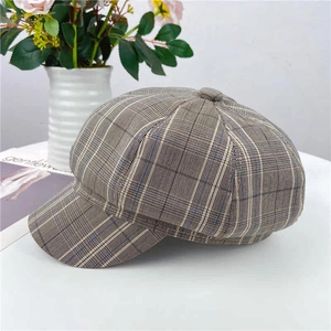 Detail of vintage plaid newsboy cap featuring wool blend texture and button top