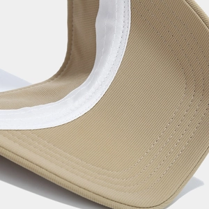 Macro view of khaki sun visor interior showing white sweatband and precision stitching