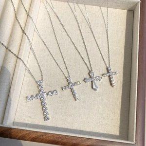 Detailed view of four S925 sterling silver cross pendants with shimmering zircon stones