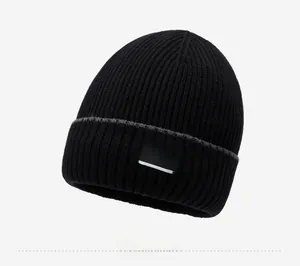 Detail of black knitted beanie showing thick ribbed texture and NY&JA fashion fabric label