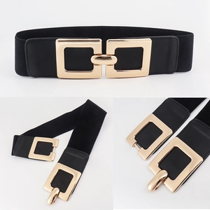 Detail showing high-stretch black fabric belt with polished gold square metal buckle