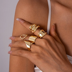 Close-up of five-piece set gold chunky geometric rings in irregular polished finish