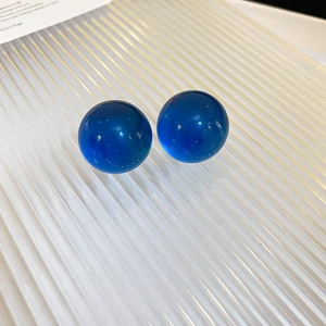 Detail of royal blue beaded earrings with translucent resin beads on a textured white tray