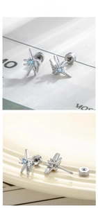 Detail view of silver star stud earrings with blue zircon and secure screw back closure