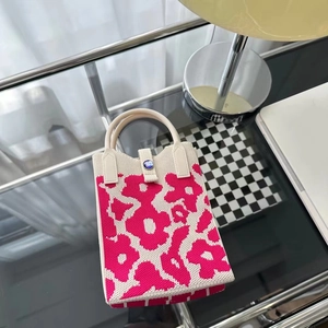 Vue détaillée d'un mini sac en tricot à fleurs roses et blanches avec poignée crème