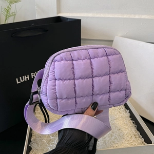 Close-up of purple quilted cross-body bag with classic lattice stitching and wide strap