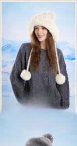 Dettaglio del cappello invernale in ecopelliccia con paraorecchie e pompon decorativi
