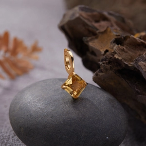 Macro detail of gold S925 sterling silver pendant with square cut yellow gemstone