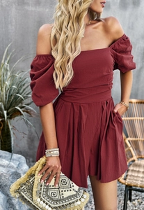 Detail view of burgundy off-shoulder romper with lantern sleeves and a belted waist design
