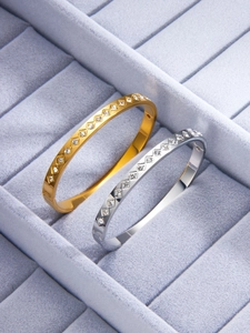 Detailed macro of gold and silver diamond rhombus titanium steel bracelets on velvet