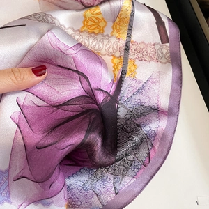 Detailed close-up of purple lily floral silk scarf with elegant lace pattern texture