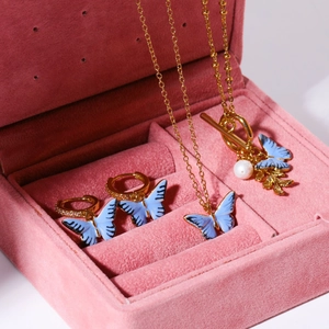 Détail de la parure papillon bleu avec perles dans un coffret en velours rose