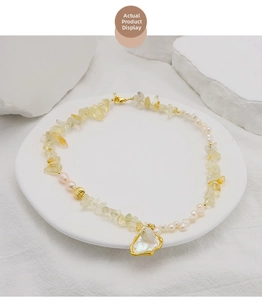 Detail showing baroque pearl and citrine beaded necklace with a golden pendant charm