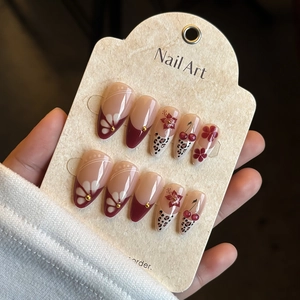 Long almond press-on nails featuring red French tips, leopard print, and 3D cherry charms