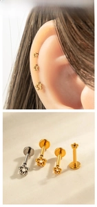 Flat back titanium flower ear studs shown in detailed close-up and model earring display