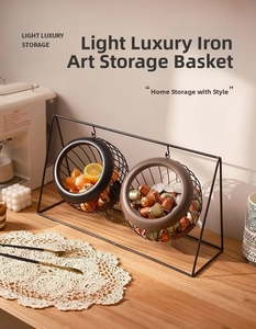 Detail of a 2-tier black iron fruit basket for countertop storage in a warm kitchen setting