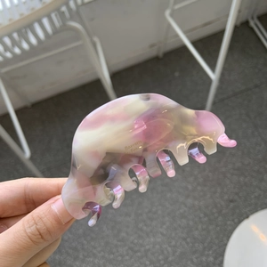 Detail of pink marble acetate hair claw with Barrette pour Femme gold lettering