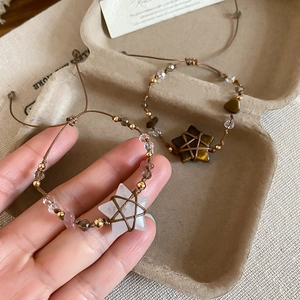 Detail of handmade ethnic braided bracelets featuring star-shaped crystals and gold beads