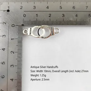 Detail of silver alloy handcuffs charm with Freedom engraving and measurement scale