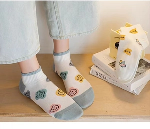 Close-up of cotton socks featuring colorful smile face prints and contrasting grey toe caps