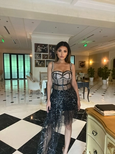 Detail of black sequined corset bodice and layered sheer mesh fabric on evening gown