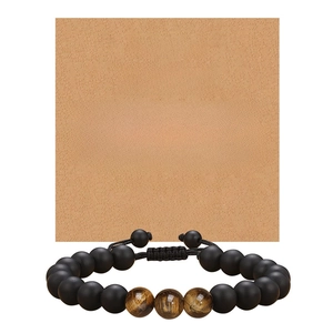 Tiger eye and matte black bead bracelet displayed on a brown kraft paper gift card