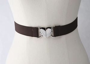 Détail de la ceinture élastique marron café avec boucle métallique argentée en forme de cœur