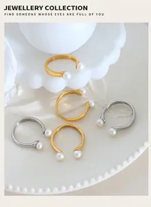 Detalle de anillos abiertos de perlas barrocas en oro y plata sobre plato de cerámica