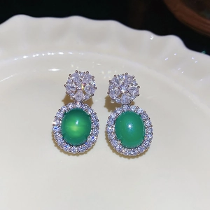 Détail de boucles d'oreilles en argent avec calcédoine verte et grappe de zircons fleurs